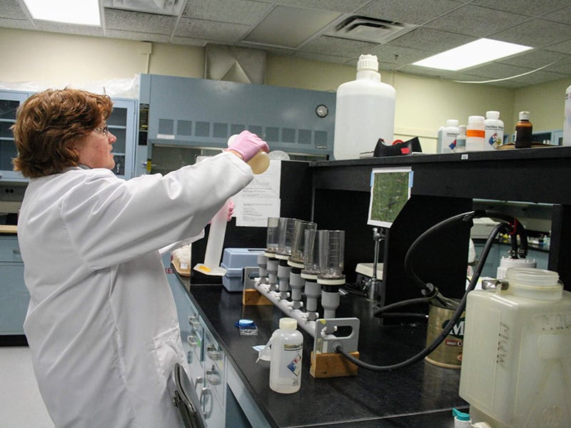 Person in lab coat testing water samples